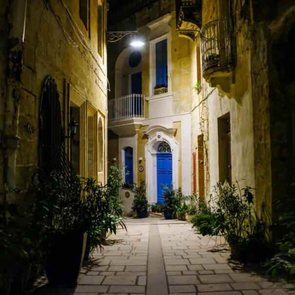 An old street at night with colourful doors and old balconies