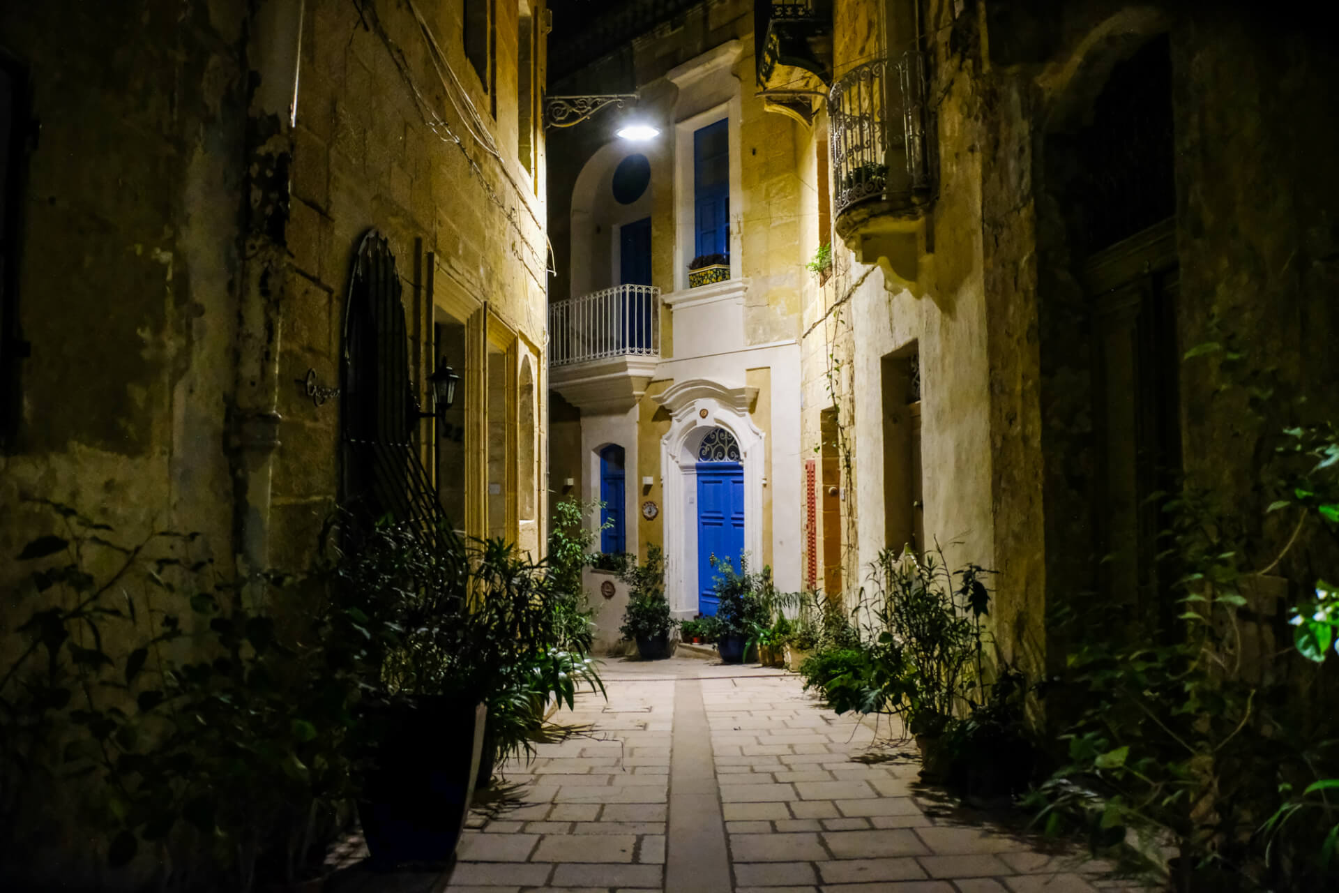 An old street at night with colourful doors and old balconies