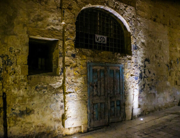 An old door set in an old wall at night