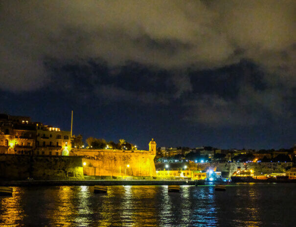 An old fort by the sea, lit up at night