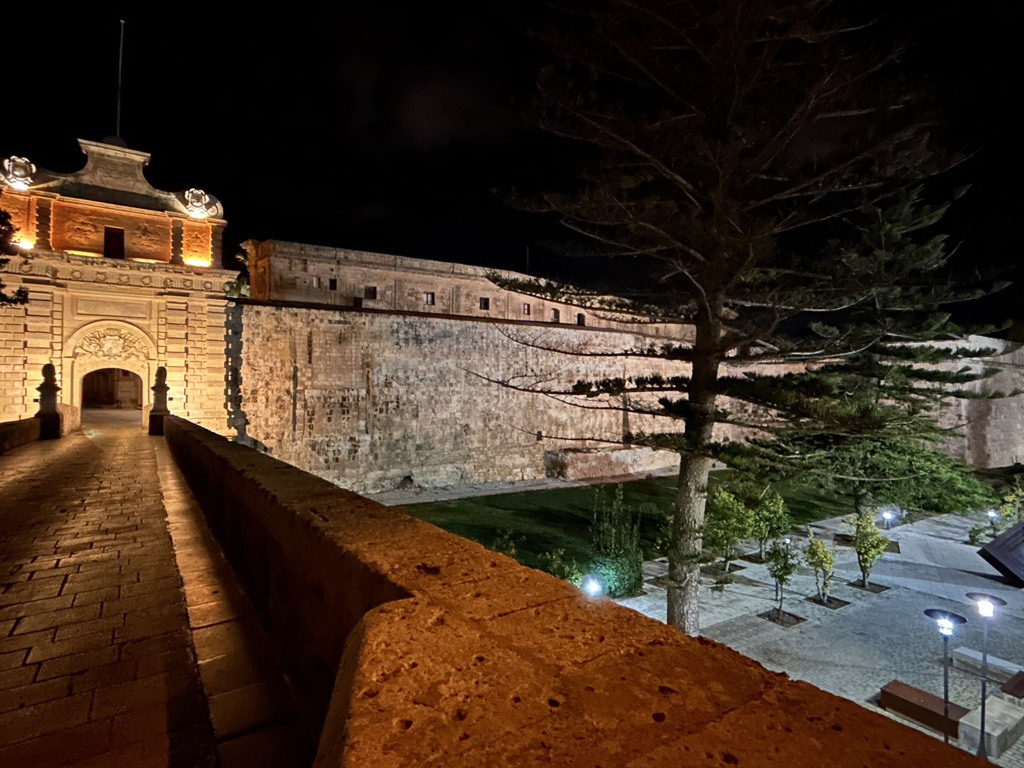 The ornate stone arch entrance to Mdina at night