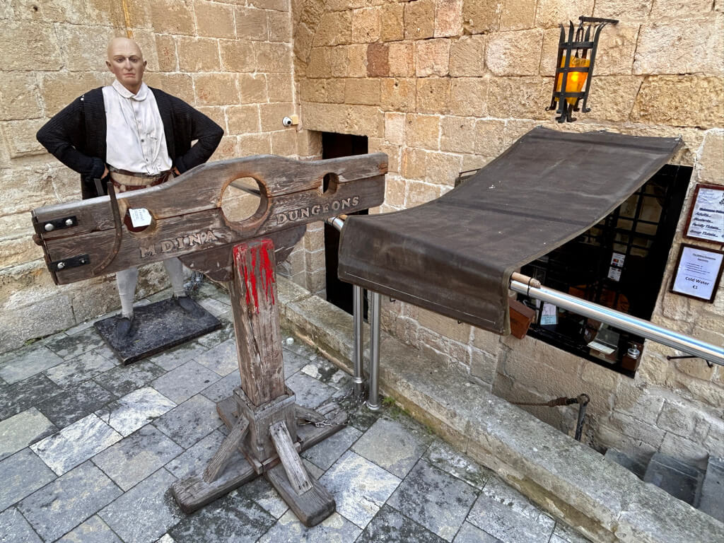 The entrance to Mdina Dungeons showing stocks and a dummy dressed as a man