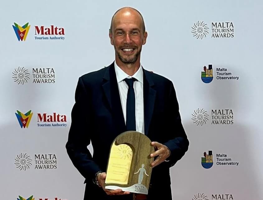 A man holding an award and smiling